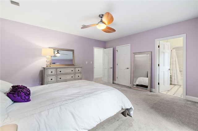 carpeted bedroom with ensuite bathroom and ceiling fan