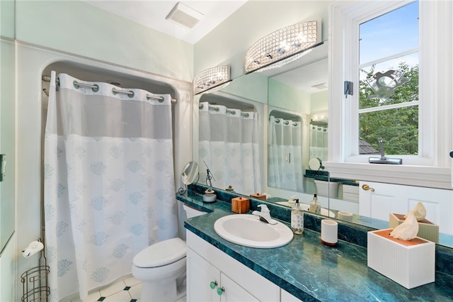 bathroom featuring a wealth of natural light, vanity, and toilet