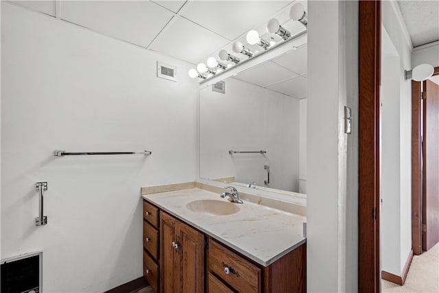 bathroom featuring a drop ceiling and large vanity