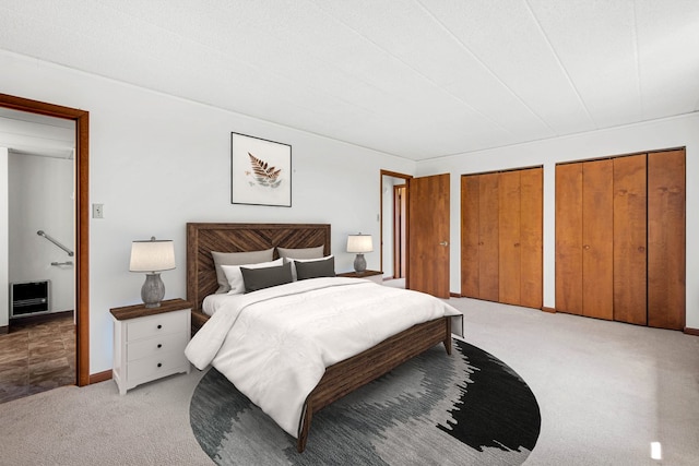 bedroom featuring multiple closets and carpet floors