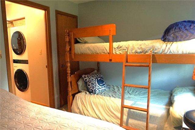 bedroom featuring a closet and stacked washer and dryer