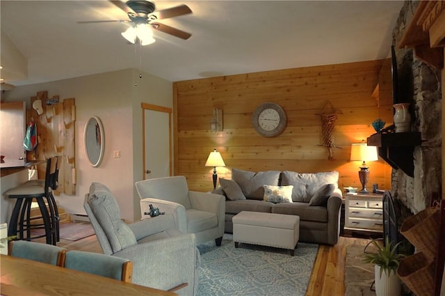 living room with a baseboard heating unit, wood walls, ceiling fan, and light hardwood / wood-style flooring