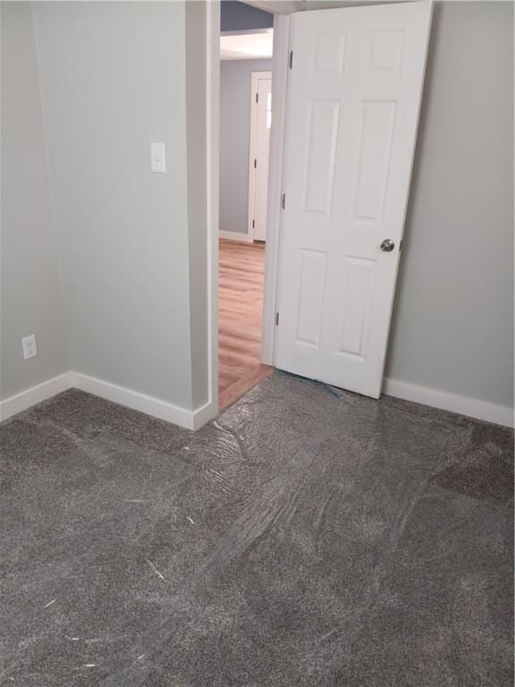 unfurnished room with dark colored carpet