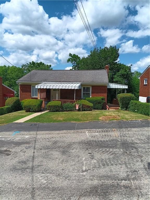 view of front of property with covered porch and a front lawn