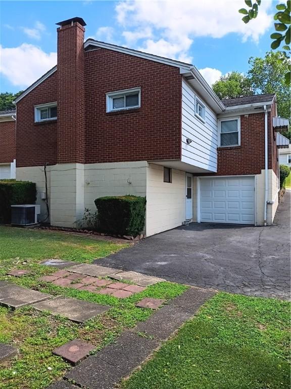 view of property exterior featuring a garage and cooling unit