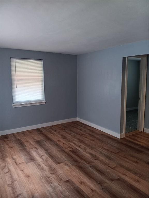 empty room with dark hardwood / wood-style flooring