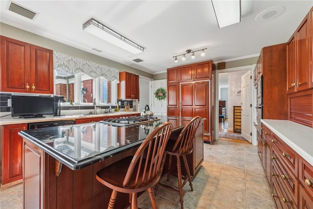 kitchen featuring a breakfast bar area, a center island, ornamental molding, and light tile flooring