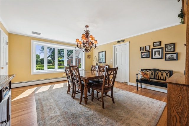 dining space with a baseboard heating unit, a chandelier, ornamental molding, and light wood-type flooring