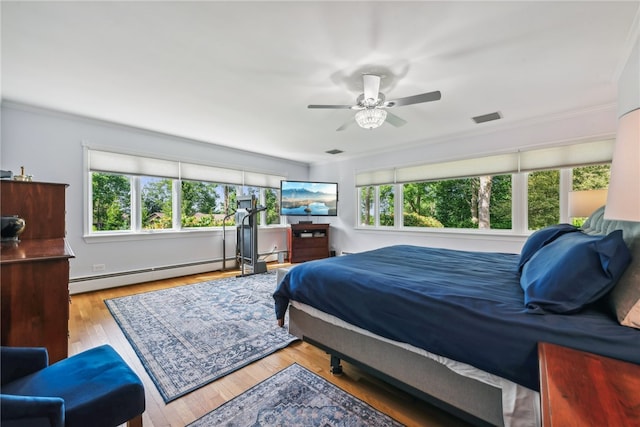 bedroom featuring ceiling fan, multiple windows, light hardwood / wood-style floors, and baseboard heating