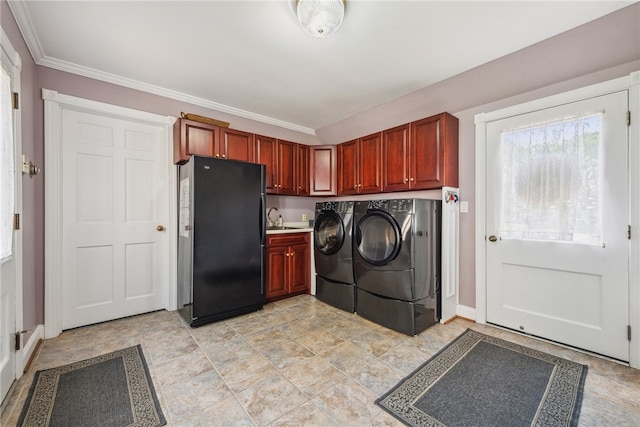 laundry room with crown molding, light tile flooring, washing machine and dryer, sink, and cabinets