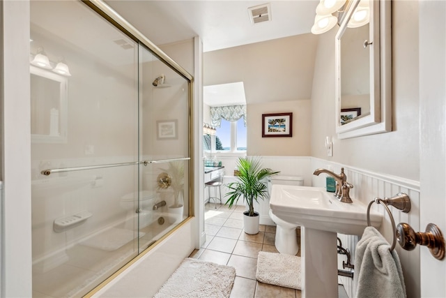 bathroom featuring tile floors and bath / shower combo with glass door