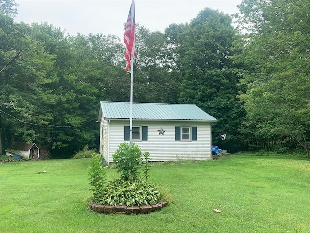 view of front of property with a front lawn and a storage shed