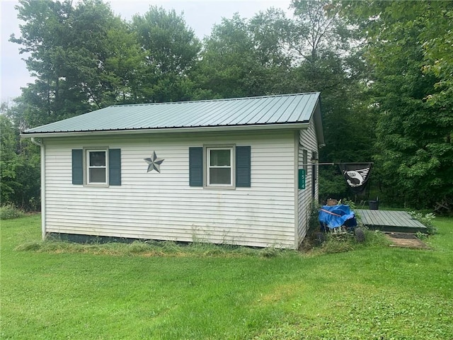 view of side of home with a yard and metal roof