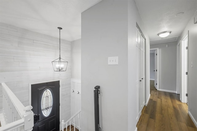 entryway featuring an inviting chandelier and dark wood-type flooring