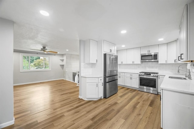 kitchen featuring white cabinetry, stainless steel appliances, light hardwood / wood-style flooring, and sink