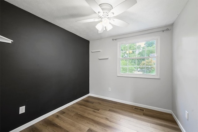 spare room featuring dark hardwood / wood-style floors and ceiling fan