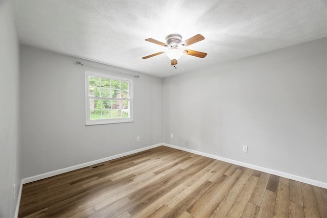 spare room featuring a textured ceiling, light wood-type flooring, and ceiling fan