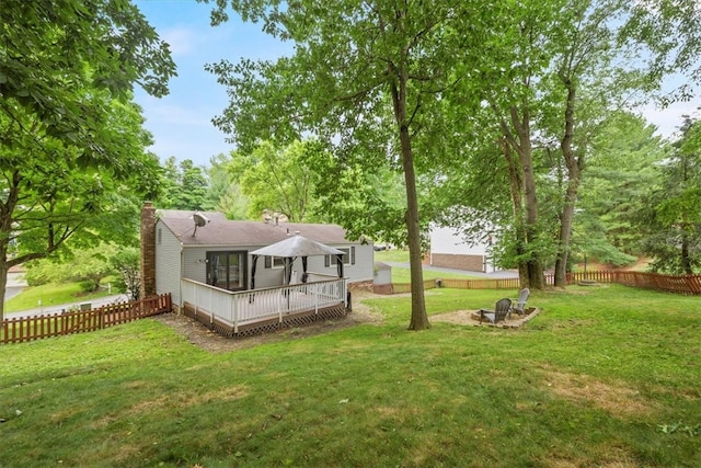 rear view of house with a deck and a yard