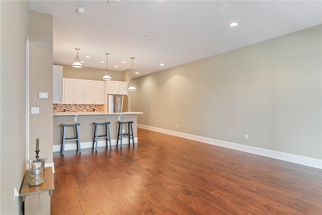 301 5th Ave Unit 603, Downtown Pgh, PA 15222 - kitchen featuring stainless steel refrigerator, a kitchen bar, a peninsula, white cabinetry, and wood finished floors