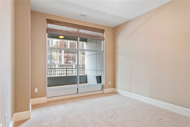 spare room featuring light colored carpet