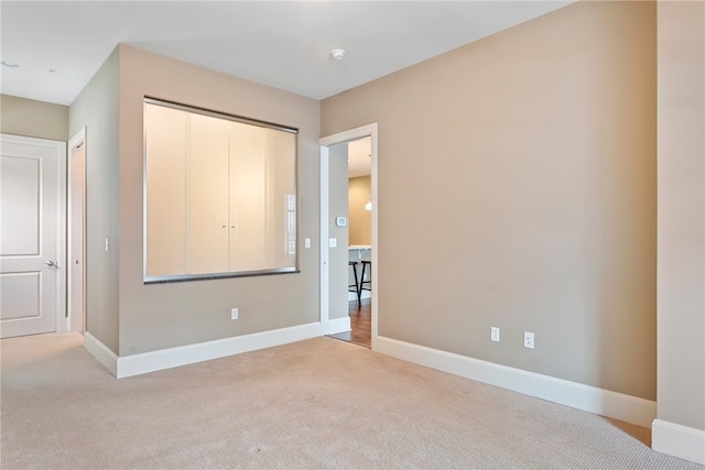 unfurnished bedroom with light carpet and a closet