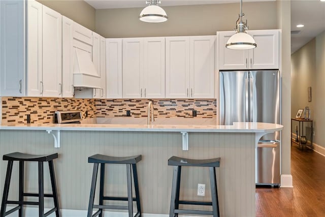 301 5th Ave Unit 603, Downtown Pgh, PA 15222 - kitchen featuring freestanding refrigerator, custom range hood, dark wood-style flooring, tasteful backsplash, and decorative light fixtures