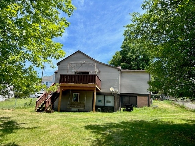 rear view of property with a lawn and a wooden deck