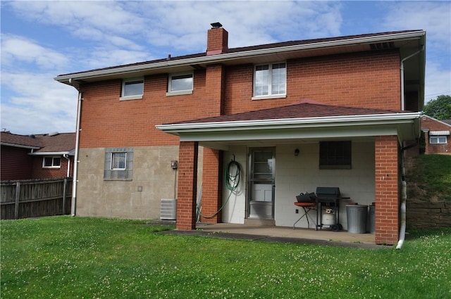 rear view of house featuring a lawn, a patio area, and central AC unit