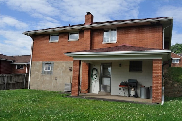 rear view of house featuring a patio and a lawn