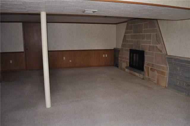 basement with carpet floors and a stone fireplace