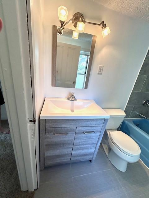 full bathroom featuring vanity, shower / bathtub combination, toilet, and a textured ceiling