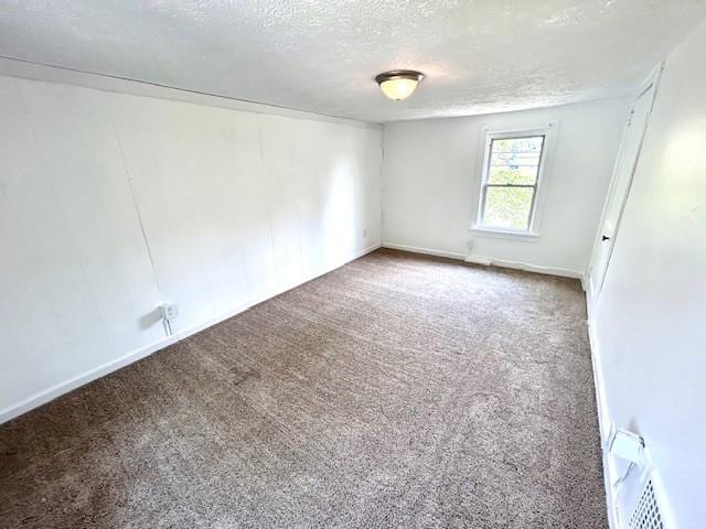 carpeted empty room with a textured ceiling