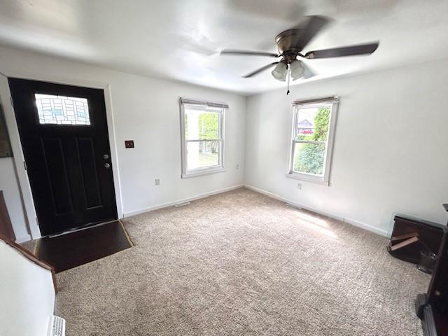 foyer entrance featuring ceiling fan and carpet flooring