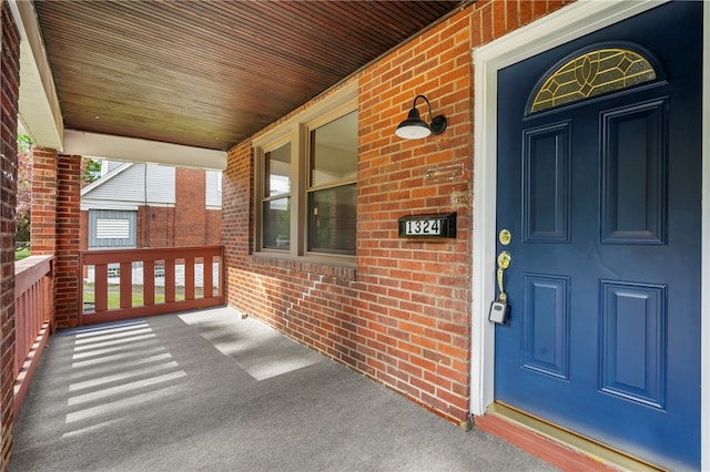 view of exterior entry featuring covered porch