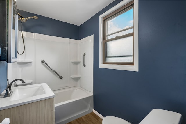 full bathroom with shower / bathtub combination, large vanity, toilet, and wood-type flooring