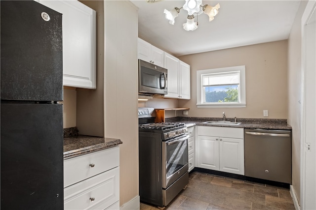 kitchen with appliances with stainless steel finishes, sink, and white cabinets