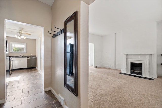 corridor featuring sink and carpet