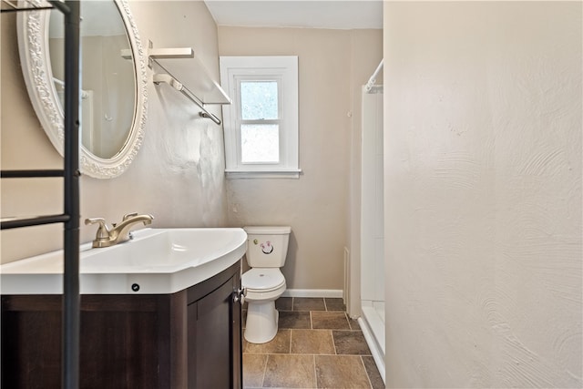 bathroom featuring a shower, vanity, and toilet