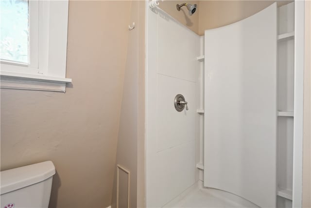 bathroom with walk in shower and toilet