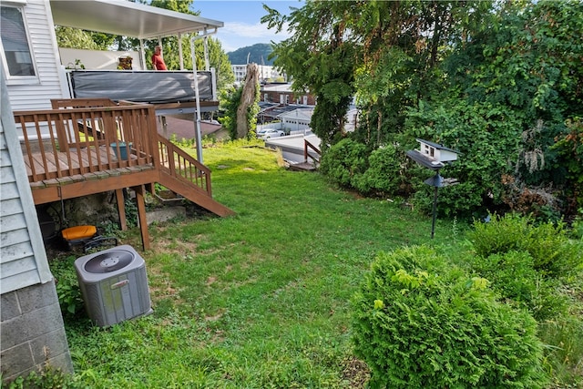 view of yard featuring a deck and central air condition unit