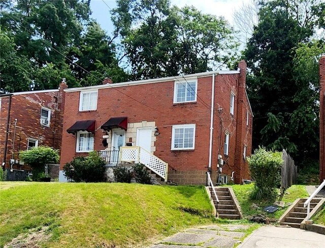 townhome / multi-family property featuring a front lawn