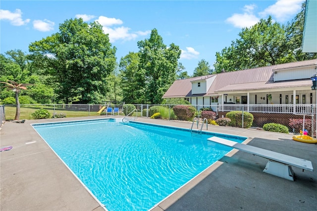 view of pool featuring a patio and a diving board