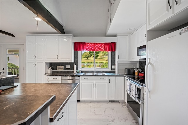 kitchen featuring white appliances, beam ceiling, backsplash, sink, and light tile floors