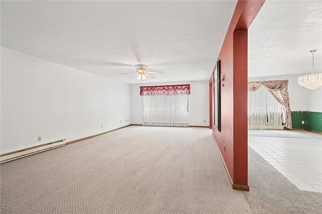 empty room featuring carpet flooring, a baseboard radiator, and ceiling fan with notable chandelier