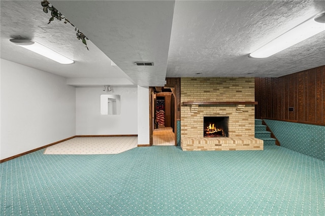 unfurnished living room featuring a textured ceiling, a fireplace, and carpet floors