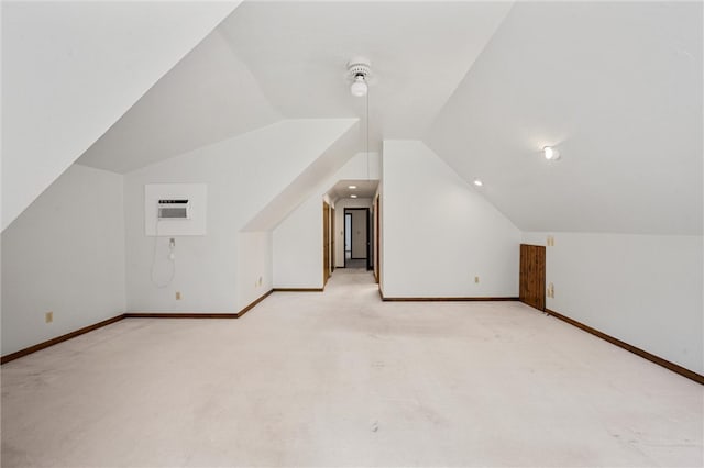 additional living space with vaulted ceiling, light colored carpet, and a wall mounted AC