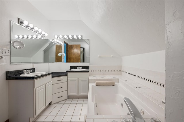 bathroom featuring a bath, tile floors, vanity with extensive cabinet space, vaulted ceiling, and dual sinks