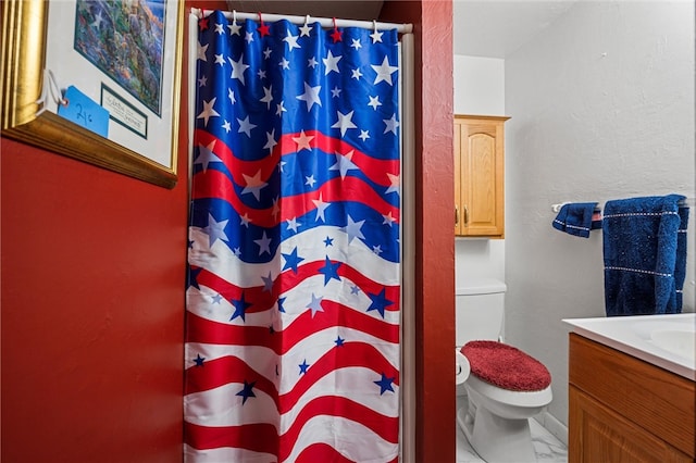 bathroom featuring tile flooring, vanity, and toilet