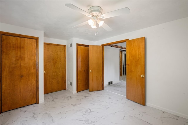 unfurnished bedroom featuring multiple closets, ceiling fan, and light tile floors