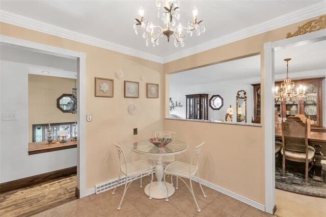 dining space with an inviting chandelier, ornamental molding, and tile floors